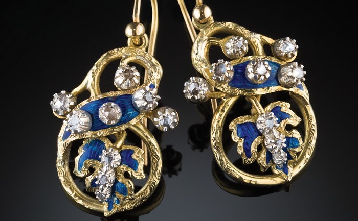 Detail of Antique pendant gold earrings with enamelled ribbon and leaf motifs embellished with rose cut diamonds set in silver